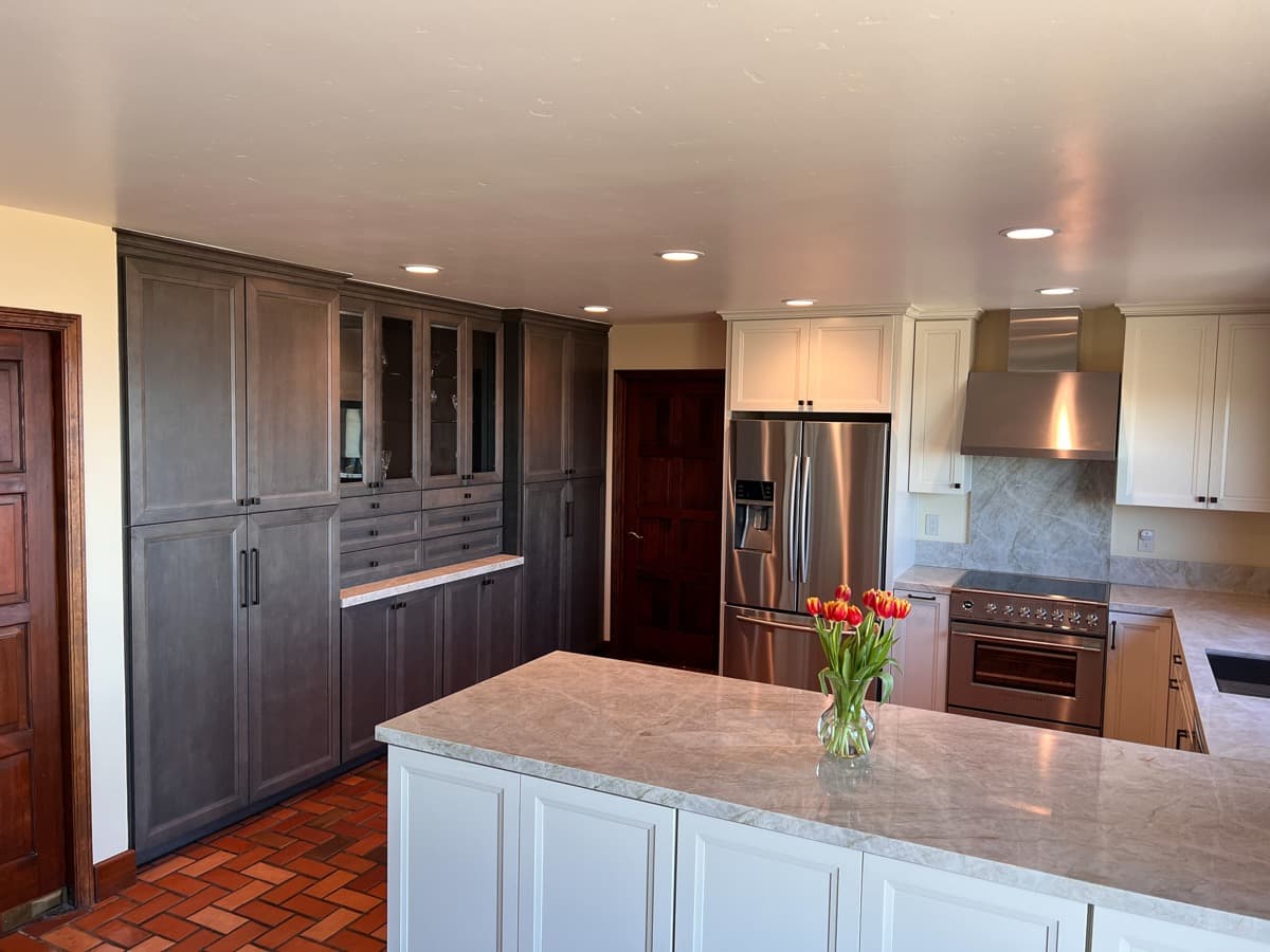 Floor-to-ceiling gray-stained built-in butler's pantry with glass-front display uppers and dovetailed drawers